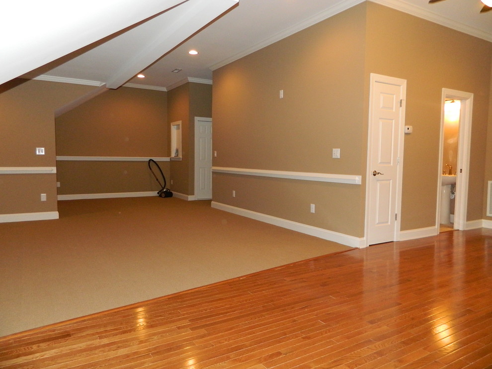 This is an example of a large traditional gender-neutral kids' playroom for kids 4-10 years old in Raleigh with beige walls and medium hardwood floors.