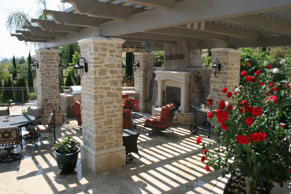 This is an example of a mid-sized mediterranean backyard patio in Boise with an outdoor kitchen, stamped concrete and a pergola.