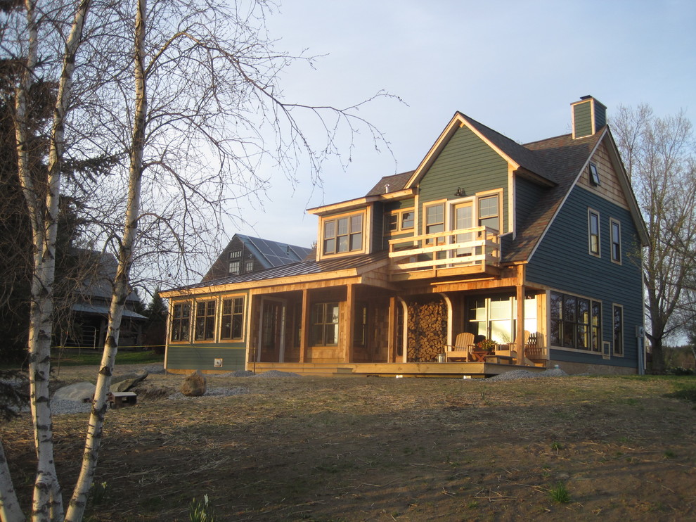 Small country three-storey green exterior in Burlington with wood siding.