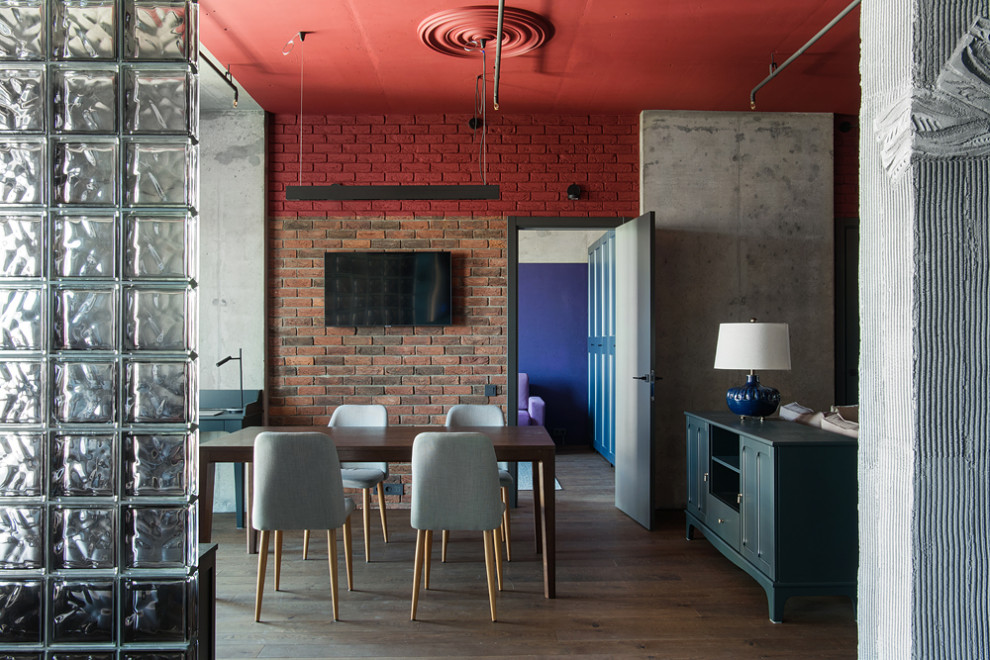 Ejemplo de despacho industrial de tamaño medio sin chimenea con paredes rojas, suelo de madera oscura, escritorio independiente, suelo marrón y ladrillo