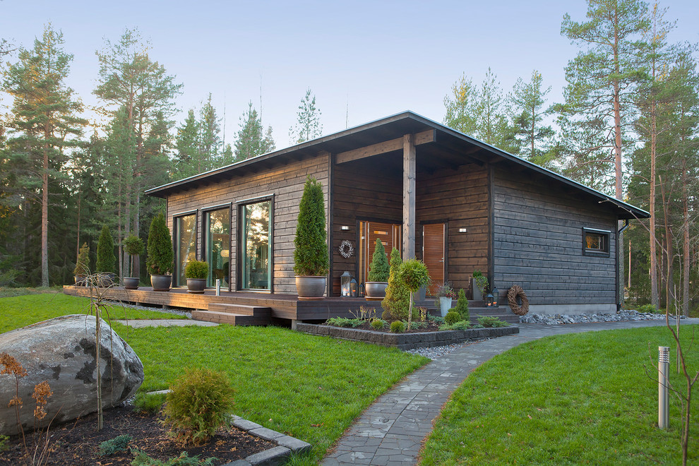 Mid-sized country one-storey brown house exterior in Moscow with wood siding and a shed roof.