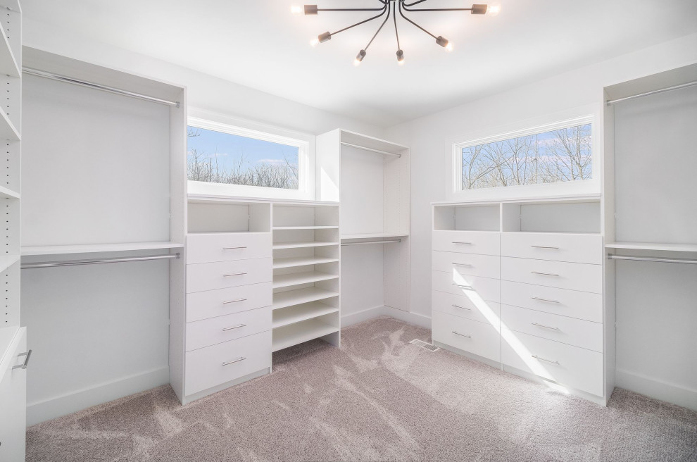 Пример оригинального дизайна: большая гардеробная комната унисекс в стиле модернизм с белыми фасадами и ковровым покрытием