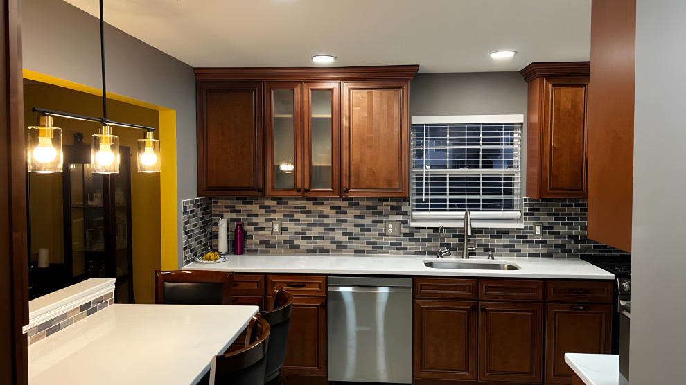 Cette photo montre une cuisine américaine moderne en U et bois foncé de taille moyenne avec un électroménager en acier inoxydable, un sol blanc, un plan de travail blanc et un plafond en bois.