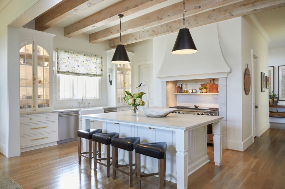 Inspiration for a large transitional l-shaped medium tone wood floor eat-in kitchen remodel in Birmingham with a farmhouse sink, recessed-panel cabinets, white cabinets, stainless steel appliances and an island