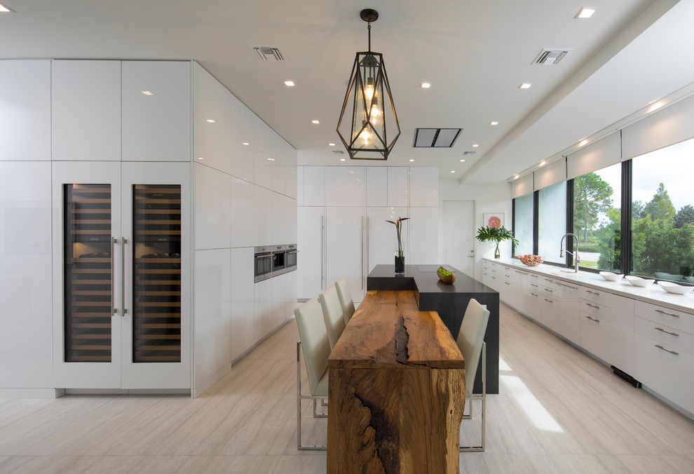 Photo of an expansive contemporary kitchen in Orlando with flat-panel cabinets, white cabinets, granite benchtops, panelled appliances, light hardwood floors, window splashback, multiple islands and beige floor.