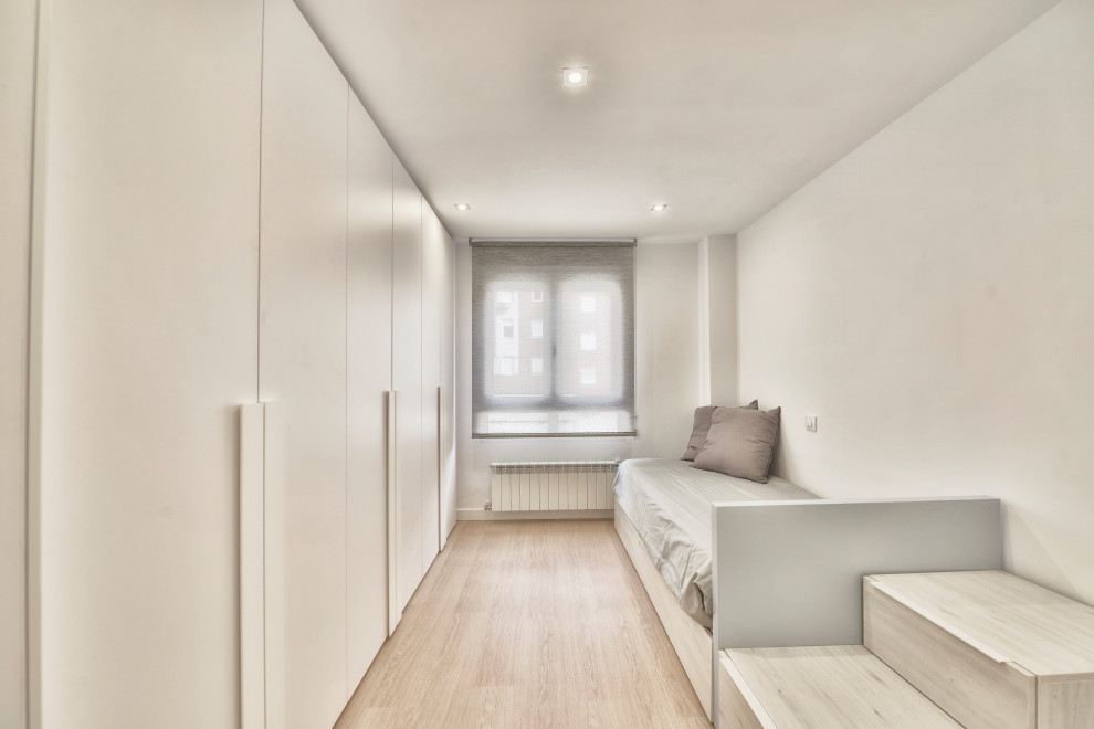 This is an example of a mid-sized scandinavian kids' bedroom for kids 4-10 years old and boys in Madrid with white walls and laminate floors.
