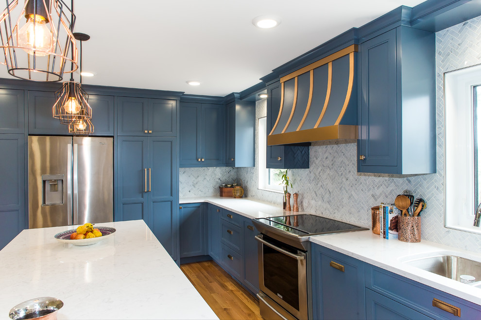 Inspiration for a large transitional l-shaped medium tone wood floor and brown floor enclosed kitchen remodel with a double-bowl sink, recessed-panel cabinets, blue cabinets, marble countertops, white backsplash, marble backsplash, stainless steel appliances and an island
