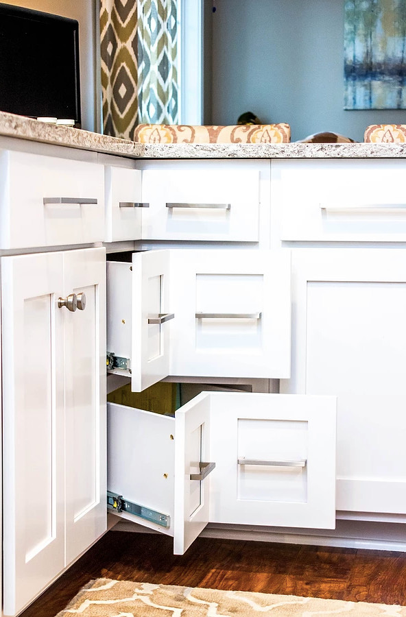 Large transitional galley medium tone wood floor and brown floor enclosed kitchen photo with an undermount sink, white cabinets, quartzite countertops, white backsplash, stainless steel appliances, shaker cabinets, ceramic backsplash, a peninsula and multicolored countertops