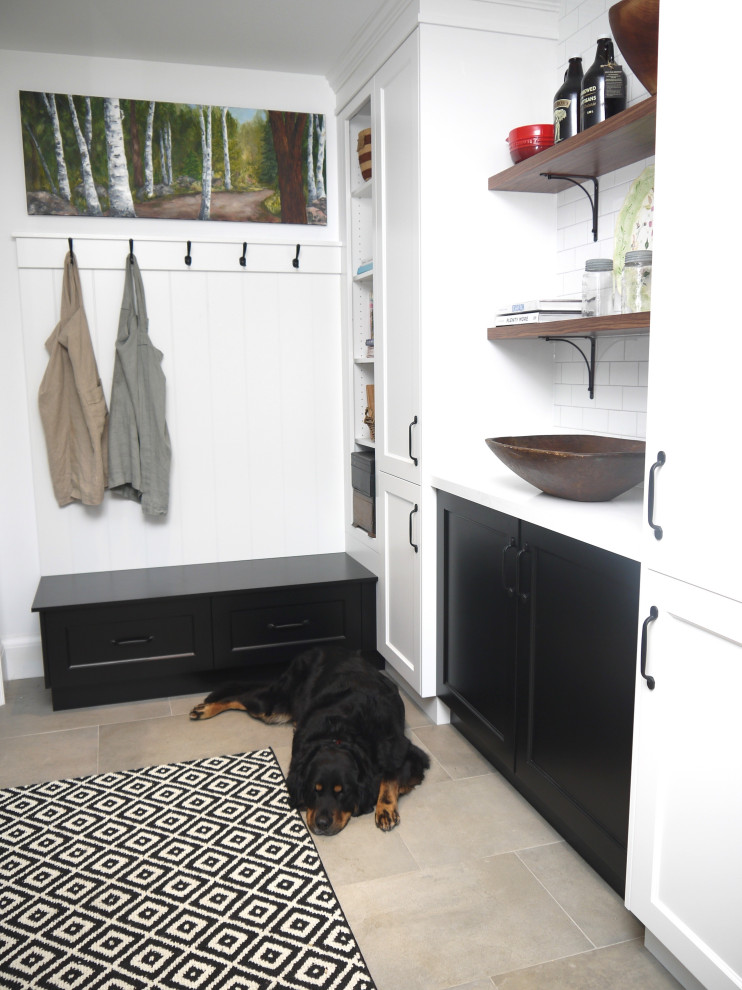 Example of a mid-sized transitional l-shaped porcelain tile and gray floor enclosed kitchen design in Toronto with a farmhouse sink, recessed-panel cabinets, white cabinets, quartz countertops, white backsplash, porcelain backsplash, stainless steel appliances, an island and white countertops