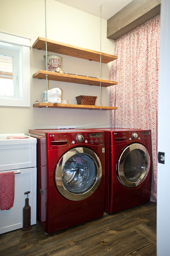 Photo of a mid-sized country utility room in Other with grey walls, medium hardwood floors and a side-by-side washer and dryer.