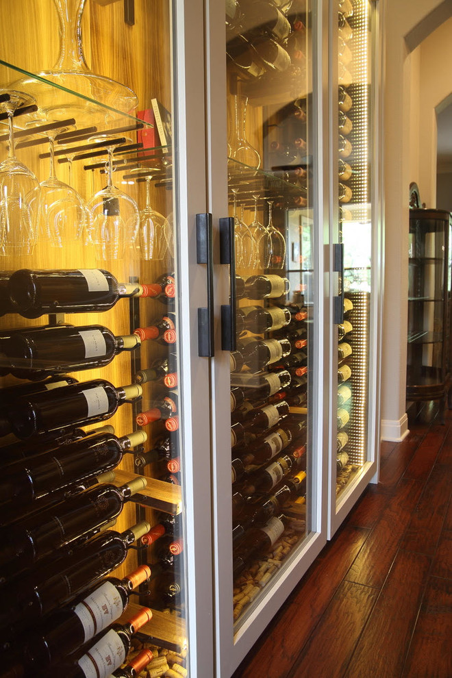 Large transitional dark wood floor and brown floor wine cellar photo with display racks
