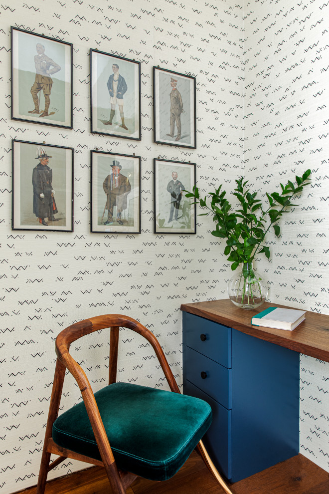 Foto de despacho bohemio pequeño con suelo de madera en tonos medios, escritorio empotrado y papel pintado