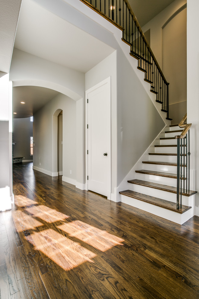 Photo of a large contemporary wood u-shaped staircase in Dallas with painted wood risers.