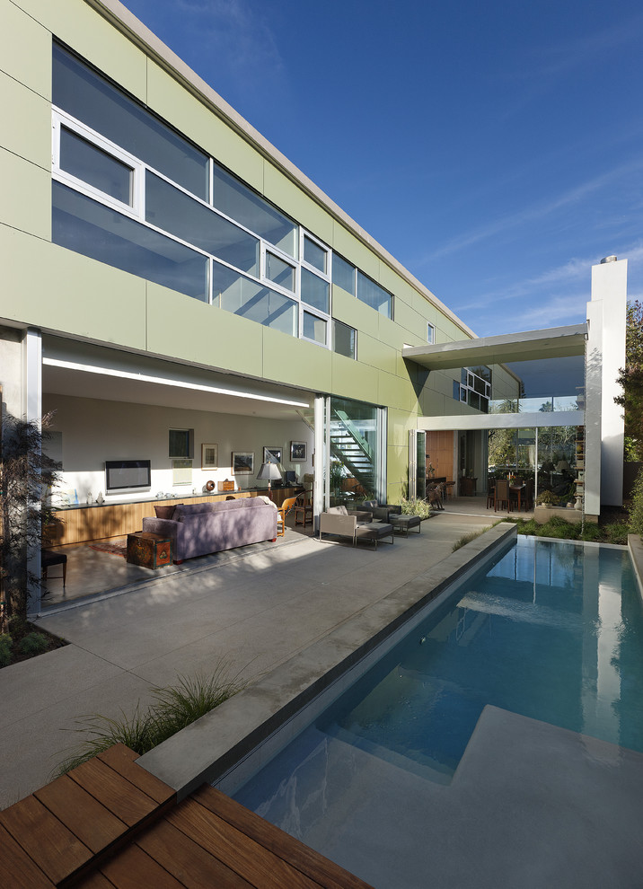 Contemporary two-storey green house exterior in Los Angeles with metal siding and a flat roof.