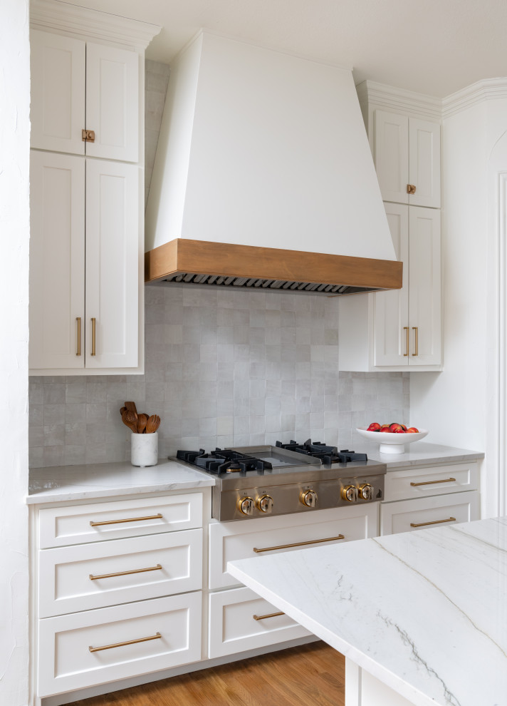 Inspiration for a medium sized traditional l-shaped open plan kitchen in Dallas with a belfast sink, recessed-panel cabinets, white cabinets, quartz worktops, white splashback, ceramic splashback, stainless steel appliances, medium hardwood flooring, an island and white worktops.