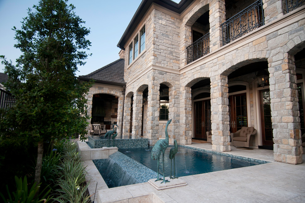 This is an example of a small contemporary courtyard rectangular infinity pool in Houston with a hot tub and tile.