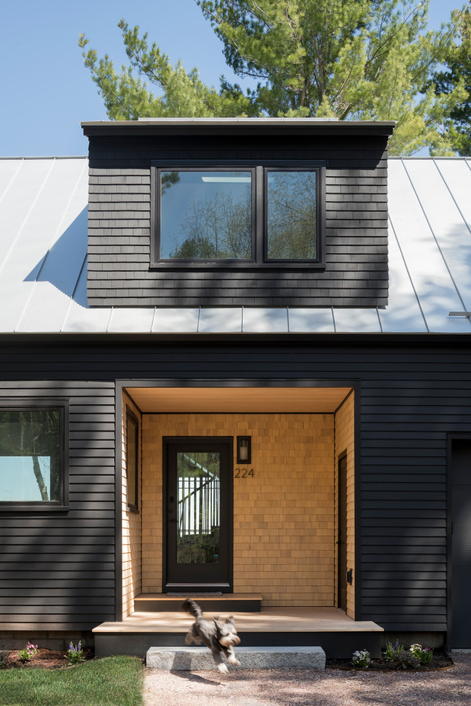 Пример оригинального дизайна: двухэтажный, деревянный, черный частный загородный дом среднего размера в стиле модернизм с двускатной крышей, металлической крышей, серой крышей и отделкой дранкой