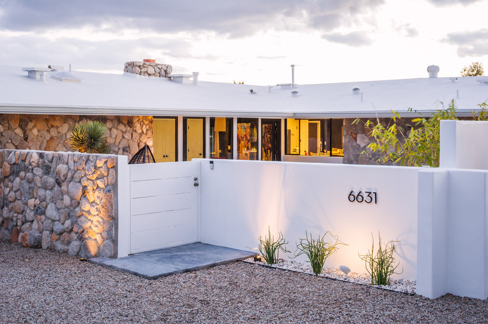 This is an example of a mid-sized mid-century modern drought-tolerant and full sun front yard stone water fountain landscape in Phoenix for fall.