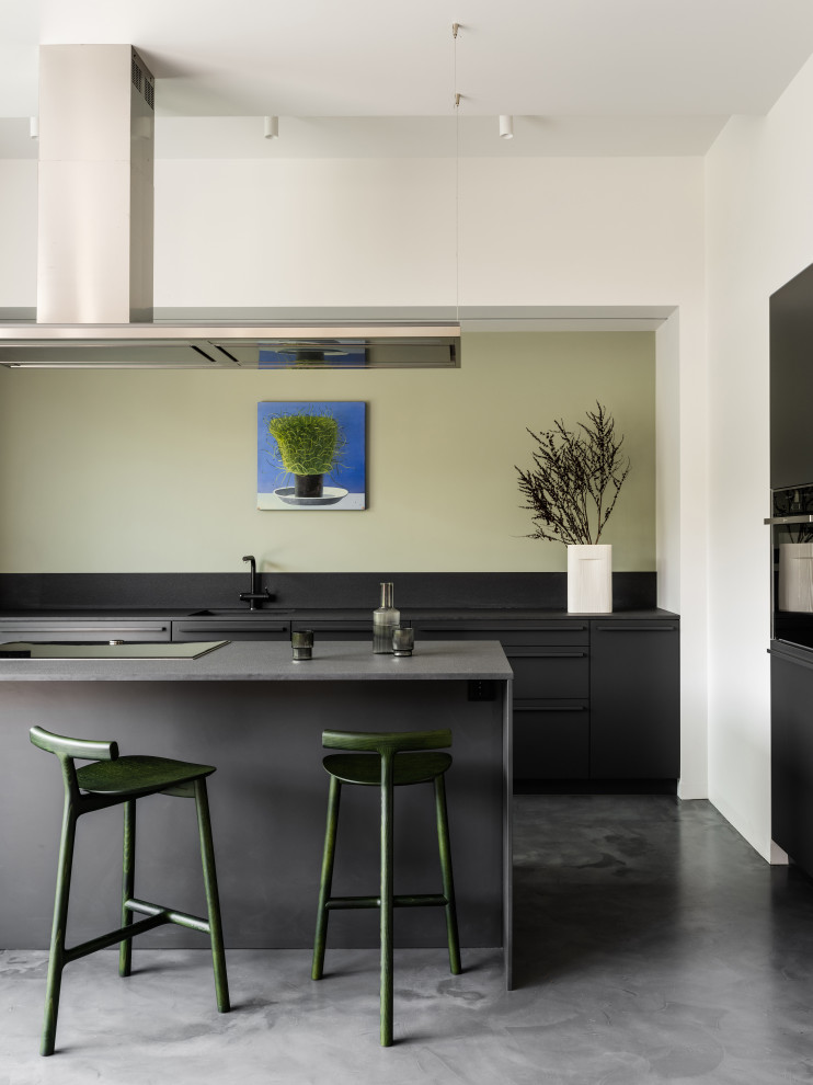 Inspiration pour une cuisine ouverte parallèle design avec des portes de placard noires et îlot.