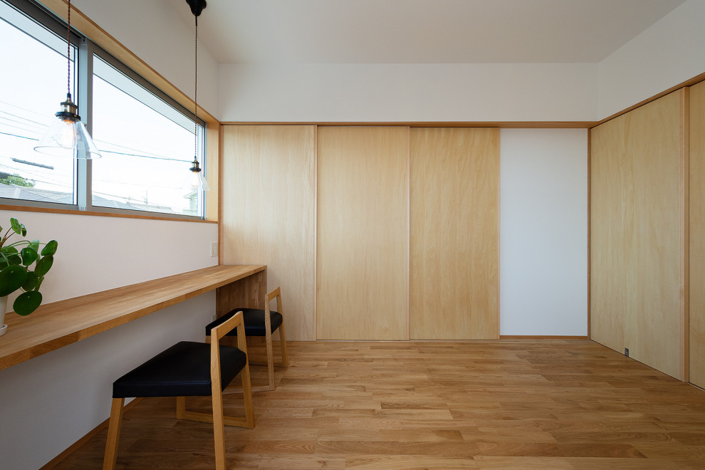 Modelo de sala de estar cerrada y blanca de estilo zen grande sin chimenea con paredes blancas, suelo de madera en tonos medios, suelo beige, papel pintado y papel pintado