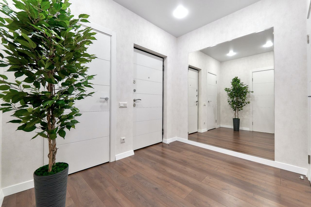 Пример оригинального дизайна: входная дверь среднего размера: освещение в современном стиле с белыми стенами, полом из керамической плитки, одностворчатой входной дверью, белой входной дверью, коричневым полом и обоями на стенах