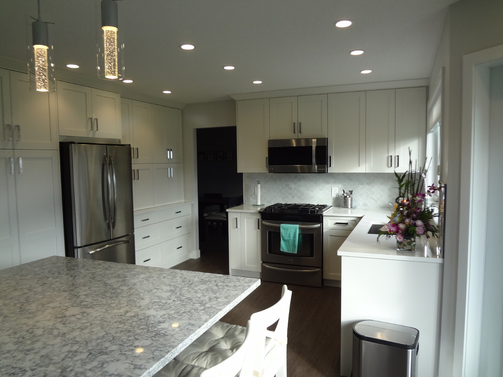 Example of a small transitional l-shaped laminate floor and gray floor open concept kitchen design with an undermount sink, shaker cabinets, white cabinets, quartz countertops, multicolored backsplash, marble backsplash, stainless steel appliances, an island and multicolored countertops