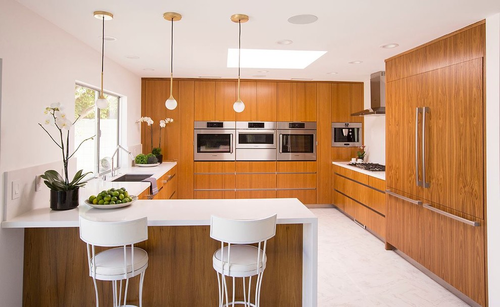 Design ideas for a mid-sized modern u-shaped eat-in kitchen in Houston with an undermount sink, flat-panel cabinets, medium wood cabinets, quartz benchtops, glass sheet splashback, stainless steel appliances, marble floors and a peninsula.