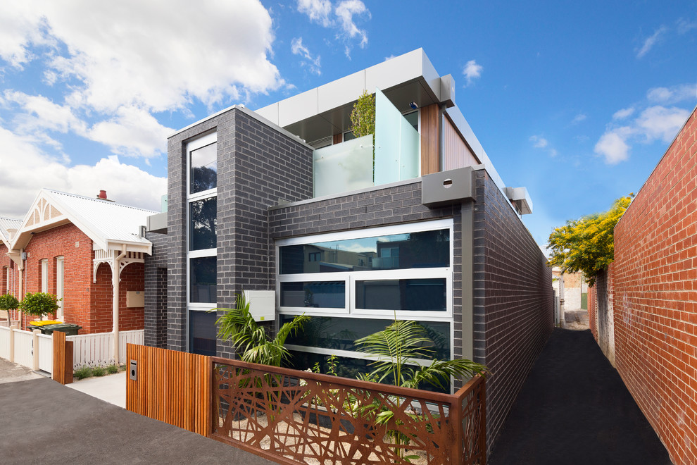 Photo of a contemporary two-storey brick exterior in Melbourne with a flat roof.