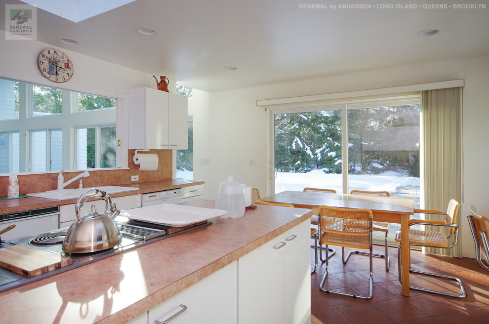 Foto di una cucina di medie dimensioni con lavello da incasso, ante lisce, ante bianche, top in laminato, paraspruzzi beige, elettrodomestici bianchi, pavimento in terracotta, pavimento marrone e top beige