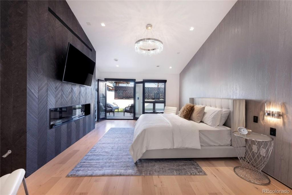 Mittelgroßes Modernes Hauptschlafzimmer mit grauer Wandfarbe, hellem Holzboden, Gaskamin, gefliester Kaminumrandung, beigem Boden, gewölbter Decke und Tapetenwänden in Denver