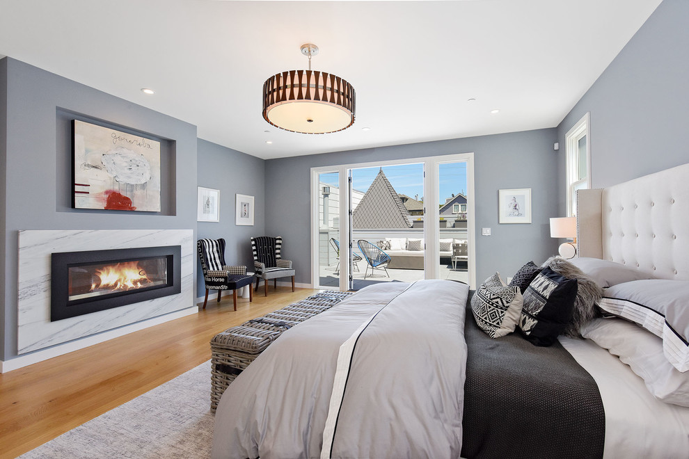 Inspiration for a transitional master bedroom in San Francisco with grey walls, medium hardwood floors, beige floor, a ribbon fireplace and a plaster fireplace surround.