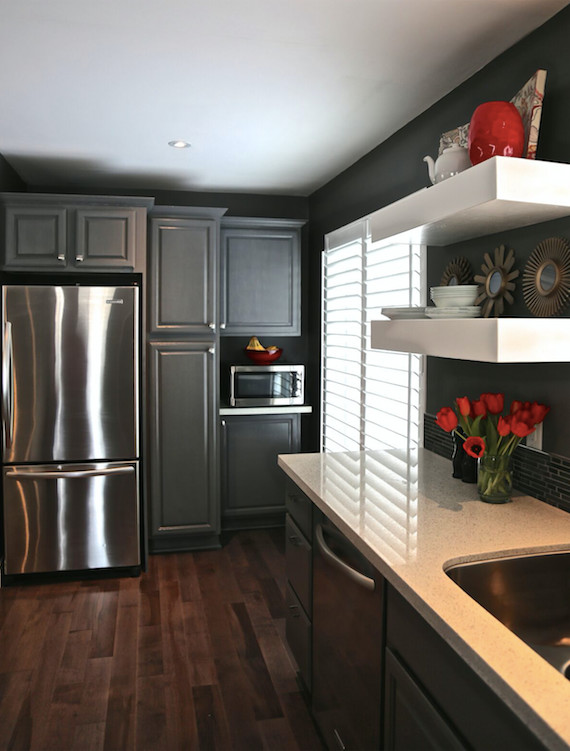 This is an example of a transitional galley open plan kitchen in Toronto with a double-bowl sink, raised-panel cabinets, grey cabinets, quartzite benchtops, black splashback, mosaic tile splashback, stainless steel appliances, dark hardwood floors and a peninsula.