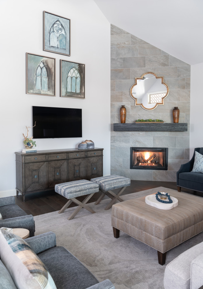 This is an example of a transitional open concept living room in Dallas with white walls, dark hardwood floors, a corner fireplace, a tile fireplace surround, a wall-mounted tv, brown floor and vaulted.