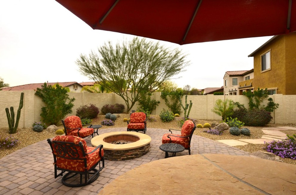 Inspiration for a large southwestern backyard brick patio remodel in Phoenix with a fire pit and no cover