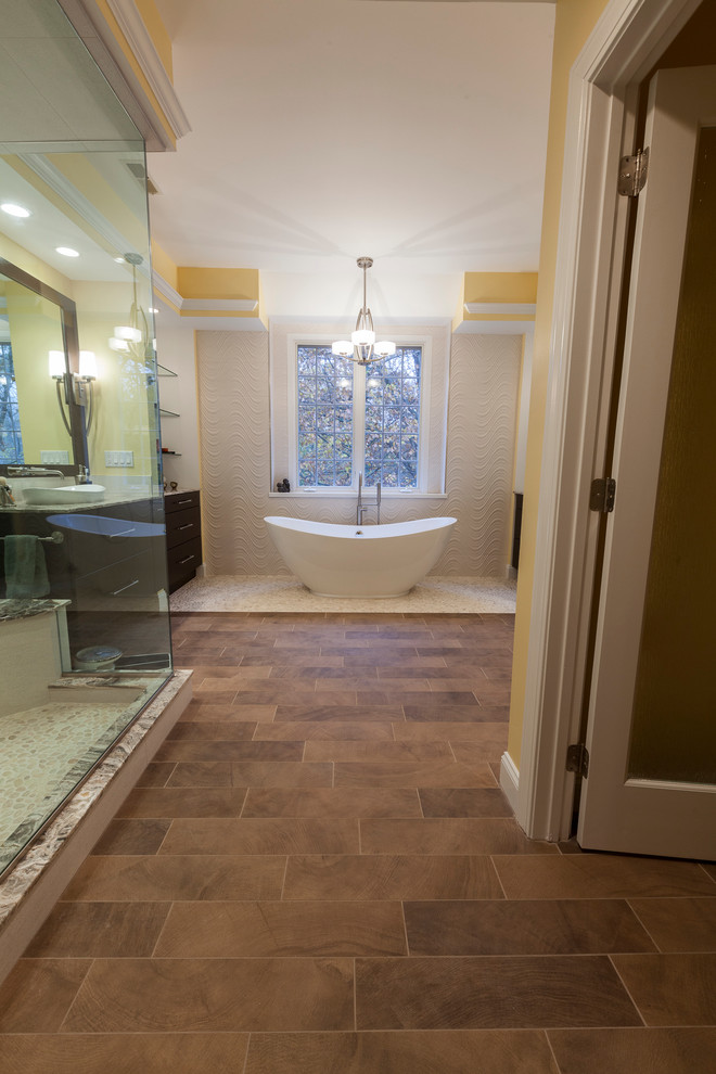 Design ideas for a large contemporary master bathroom in Bridgeport with a vessel sink, flat-panel cabinets, dark wood cabinets, onyx benchtops, a freestanding tub, a corner shower, a two-piece toilet, beige tile, porcelain tile, yellow walls and porcelain floors.