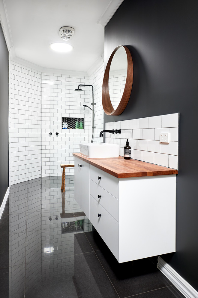This is an example of a mid-sized transitional master bathroom in Melbourne with flat-panel cabinets, white cabinets, a drop-in tub, a corner shower, a two-piece toilet, black and white tile, ceramic tile, a vessel sink, wood benchtops, a hinged shower door and brown benchtops.