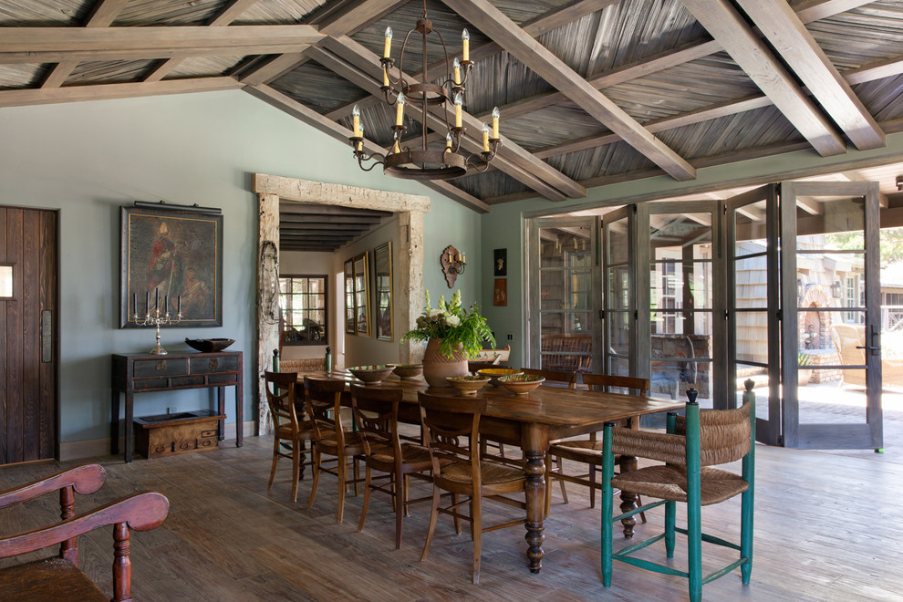 This is an example of a country dining room in San Diego with blue walls, dark hardwood floors and brown floor.
