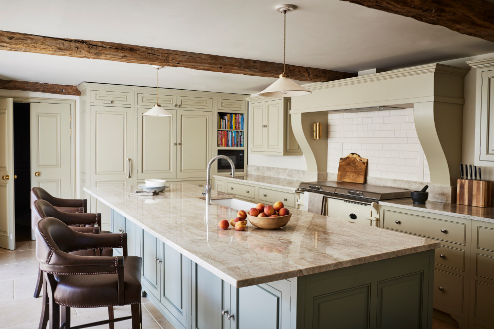 Photo of a traditional kitchen in Wiltshire with a farmhouse sink, beaded inset cabinets, beige cabinets, white splashback, subway tile splashback, with island, beige floor and beige benchtop.