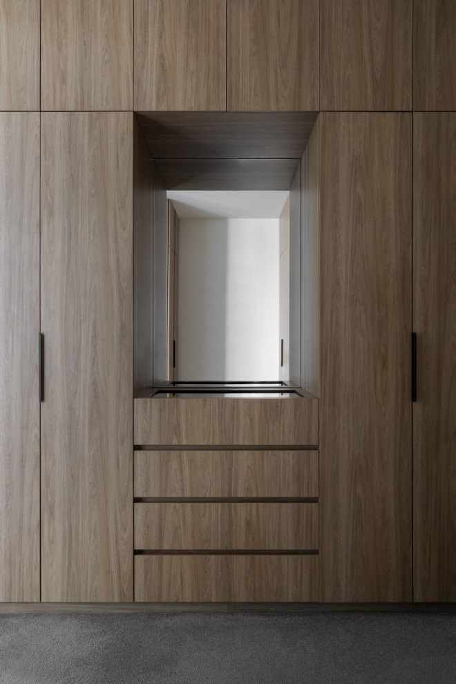 Example of a mid-sized trendy gender-neutral carpeted built-in closet design in Melbourne