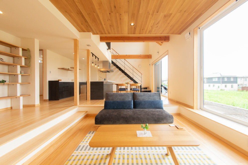 Идея дизайна: большая открытая гостиная комната в стиле лофт с белыми стенами, паркетным полом среднего тона, бежевым полом, деревянным потолком и синим диваном без камина