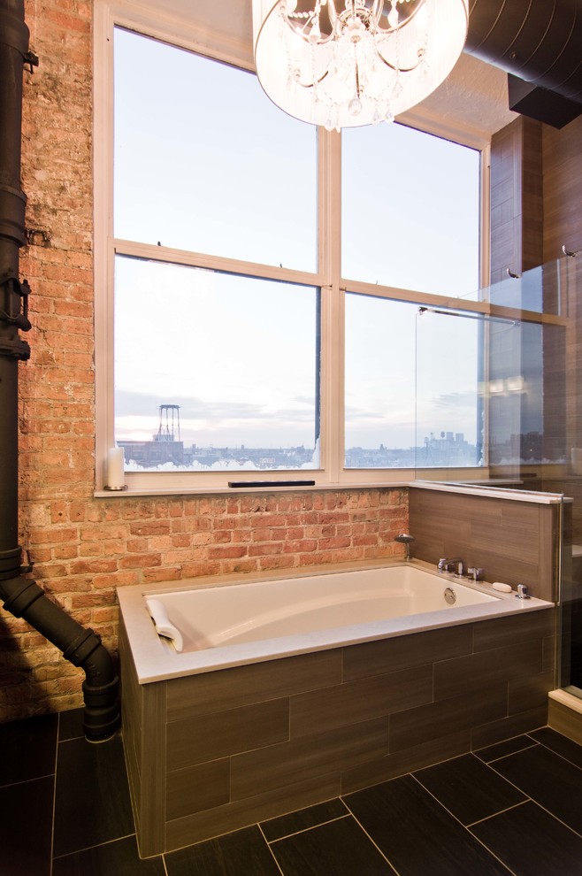 This is an example of an industrial master bathroom in Chicago with an undermount sink, raised-panel cabinets, dark wood cabinets, quartzite benchtops, a drop-in tub, an open shower, a one-piece toilet, porcelain tile, white walls and porcelain floors.