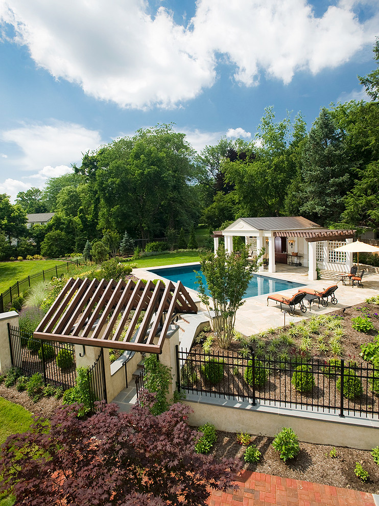 Mid-sized traditional backyard rectangular pool in Philadelphia with a pool house and natural stone pavers.