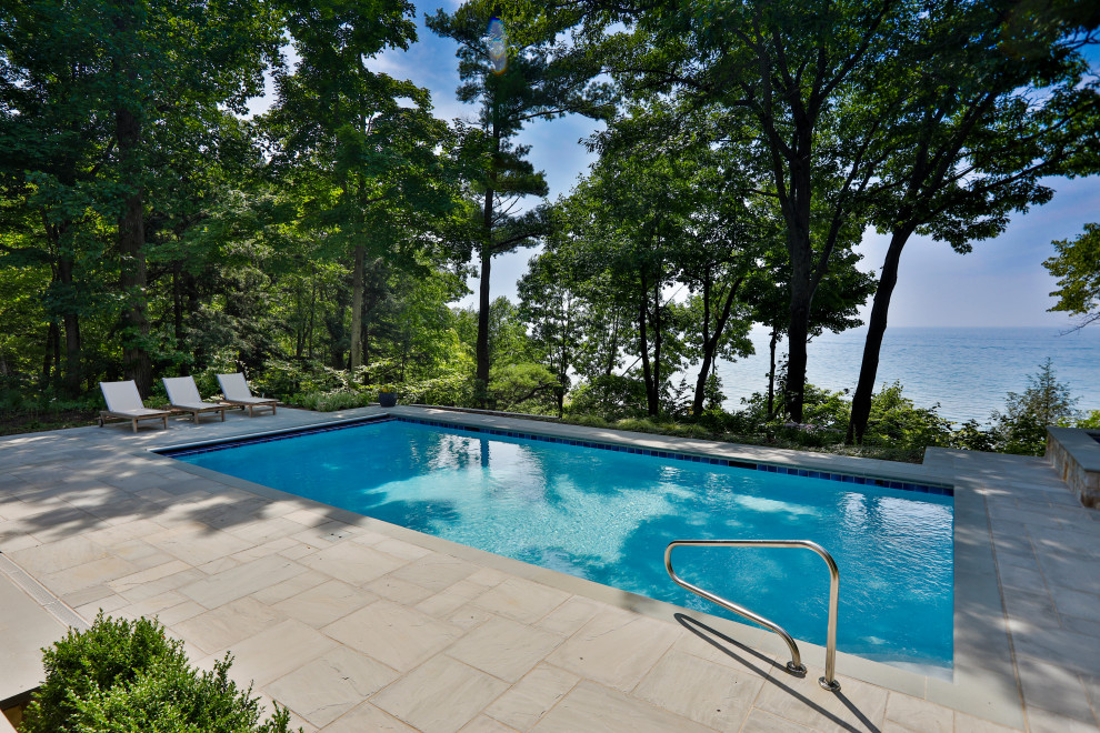 Mid-sized elegant backyard stone and rectangular lap and privacy pool photo in Chicago