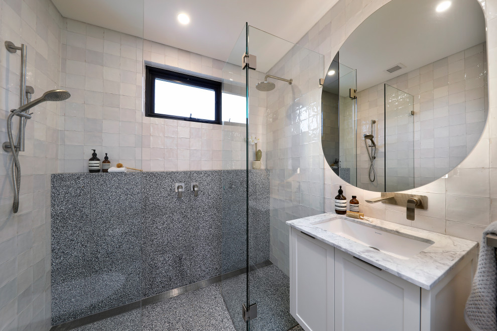 Photo of a mid-sized contemporary 3/4 bathroom in Sydney with shaker cabinets, white cabinets, a double shower, a wall-mount toilet, multi-coloured tile, porcelain tile, marble floors, an undermount sink, marble benchtops, a hinged shower door, white benchtops, a single vanity and a floating vanity.