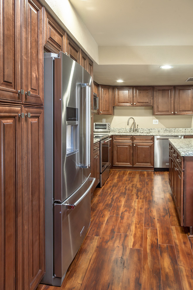 Enclosed kitchen - mid-sized transitional l-shaped laminate floor and brown floor enclosed kitchen idea in Phoenix with an undermount sink, shaker cabinets, medium tone wood cabinets, granite countertops, multicolored backsplash, stone slab backsplash, stainless steel appliances and an island