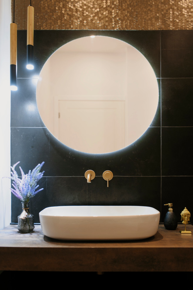 Foto på ett mellanstort funkis brun badrum, med bruna skåp, ett platsbyggt badkar, en toalettstol med separat cisternkåpa, svart kakel, porslinskakel, vita väggar, ett fristående handfat, laminatbänkskiva och brunt golv