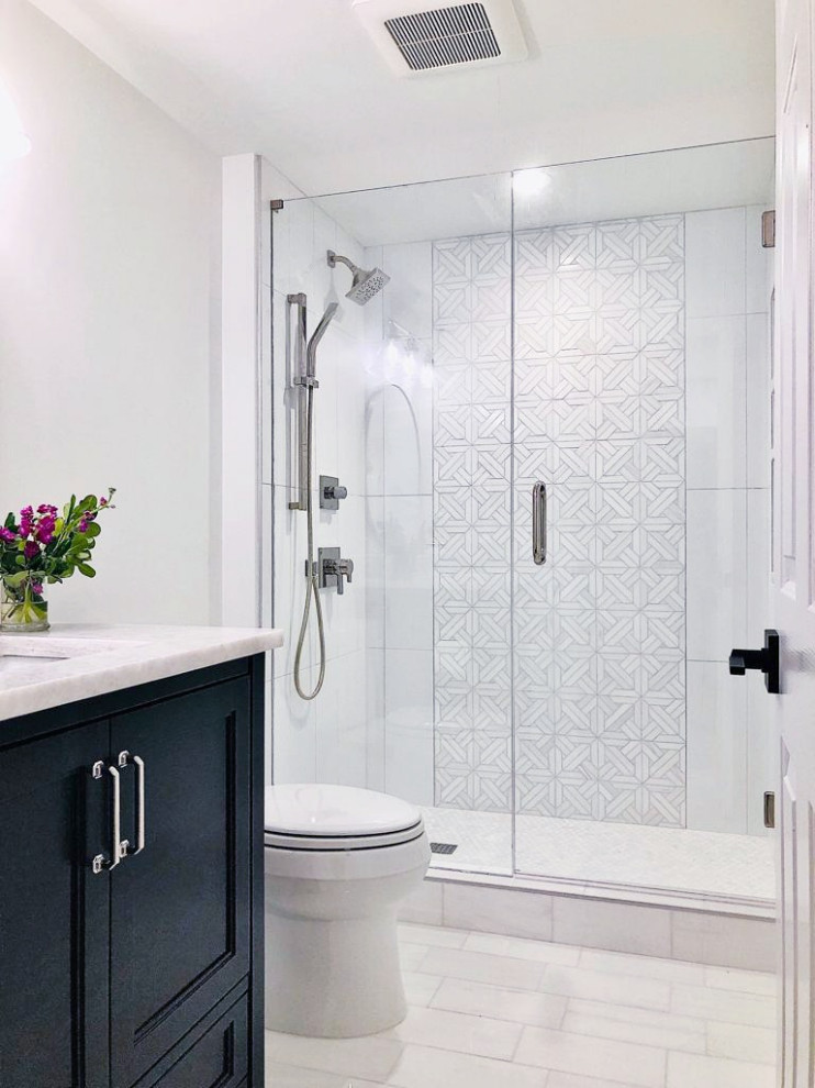 This is an example of a small classic ensuite bathroom in Atlanta with recessed-panel cabinets, black cabinets, a built-in shower, a two-piece toilet, black and white tiles, marble tiles, white walls, marble flooring, a submerged sink, quartz worktops, white floors, a hinged door, white worktops, a feature wall, a single sink and a freestanding vanity unit.