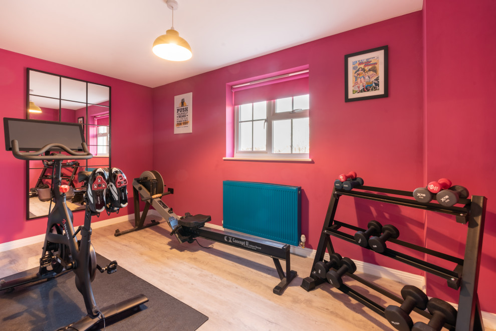 Medium sized contemporary multi-use home gym in Kent with pink walls, laminate floors, beige floors and feature lighting.