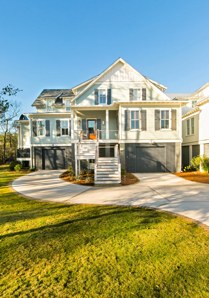 Large beach style three-storey grey house exterior in Charleston with vinyl siding, a gable roof and a shingle roof.
