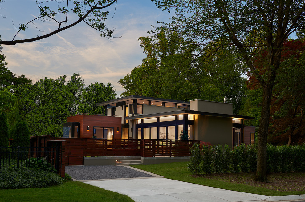 Example of a mid-sized trendy gray two-story stucco flat roof design in DC Metro with a mixed material roof
